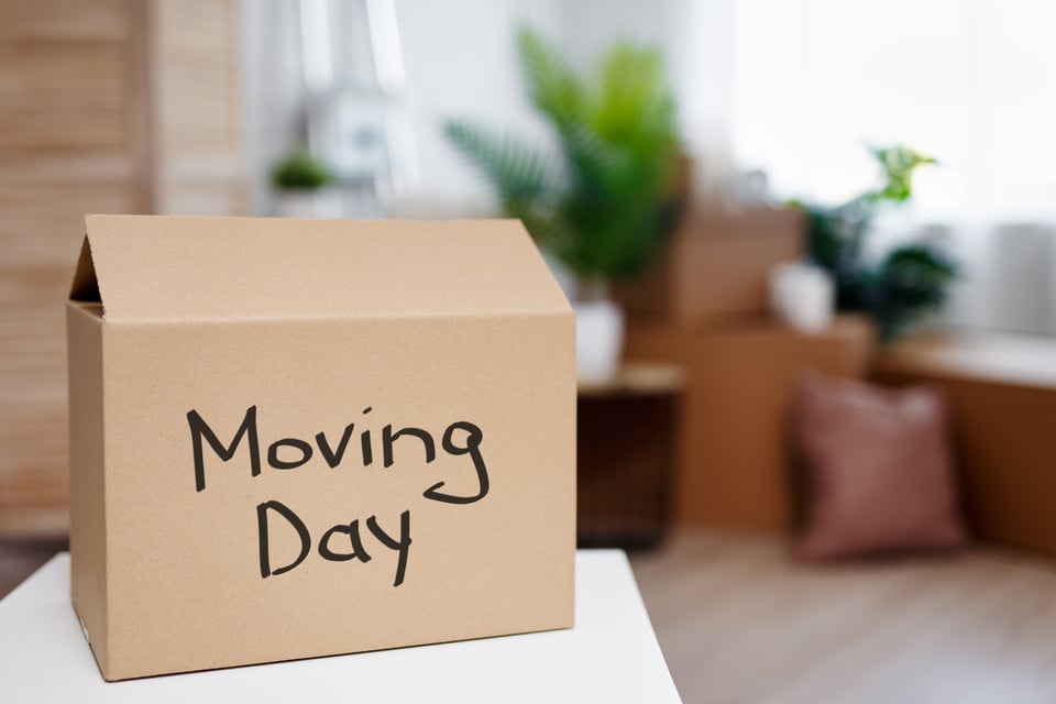 moving day concept - cardboard boxes in new house after moving day